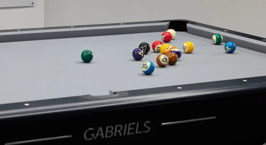 Billardtisch mit Kugeln darauf mit einigen Bildern
